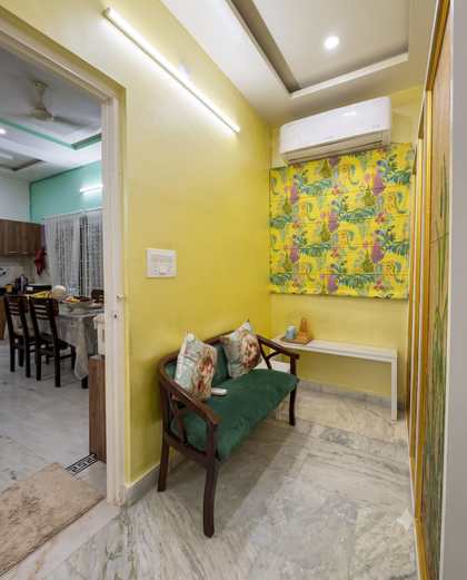 The yellow tea alcove at Renu’z Homestay with a green velvet bench by the window