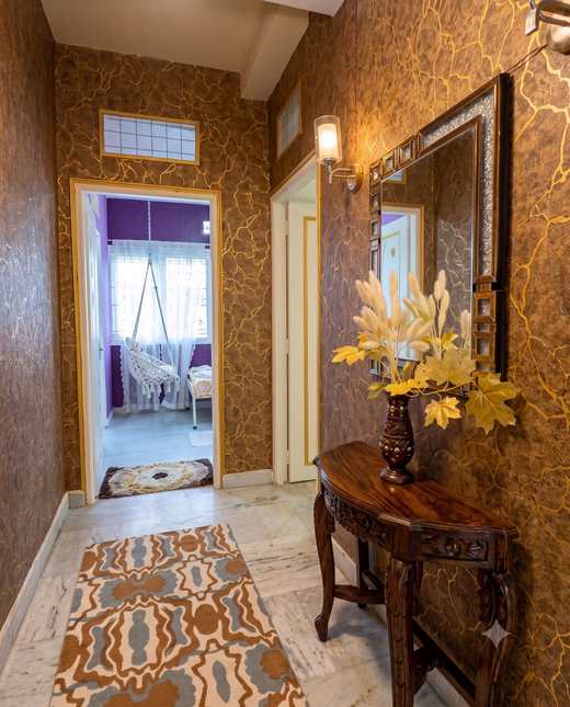 The gold corridor at Renu’z Homestay, with a carved wooden console and mirror between the rooms