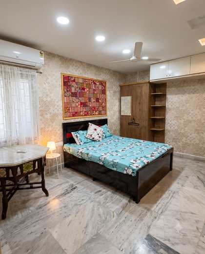 The Damask Room at Renu'z Homestay, with gold damask walls and a framed patchwork above the dark wooden bed