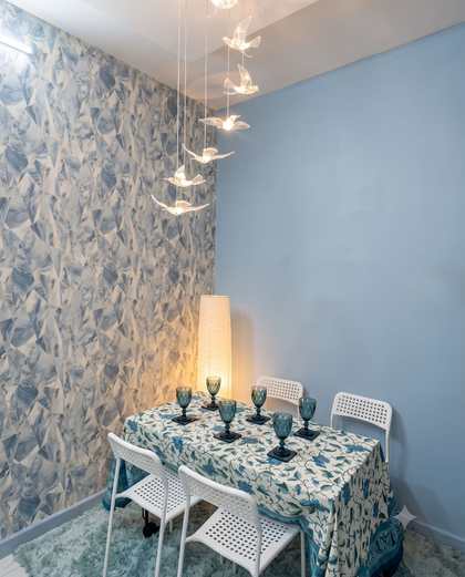 The dining table at Renu’z Homestay under a chandelier of glass birds