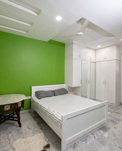The Green Room at Renu'z Homestay, with a deep emerald accent wall behind the bed