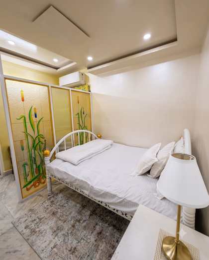 The Heritage Room at Renu'z Homestay, with a white and gold bed against ivory walls