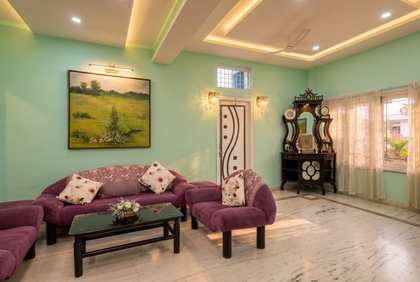 The far end of the sitting room at Renu’z Homestay, with marble floors and family paintings